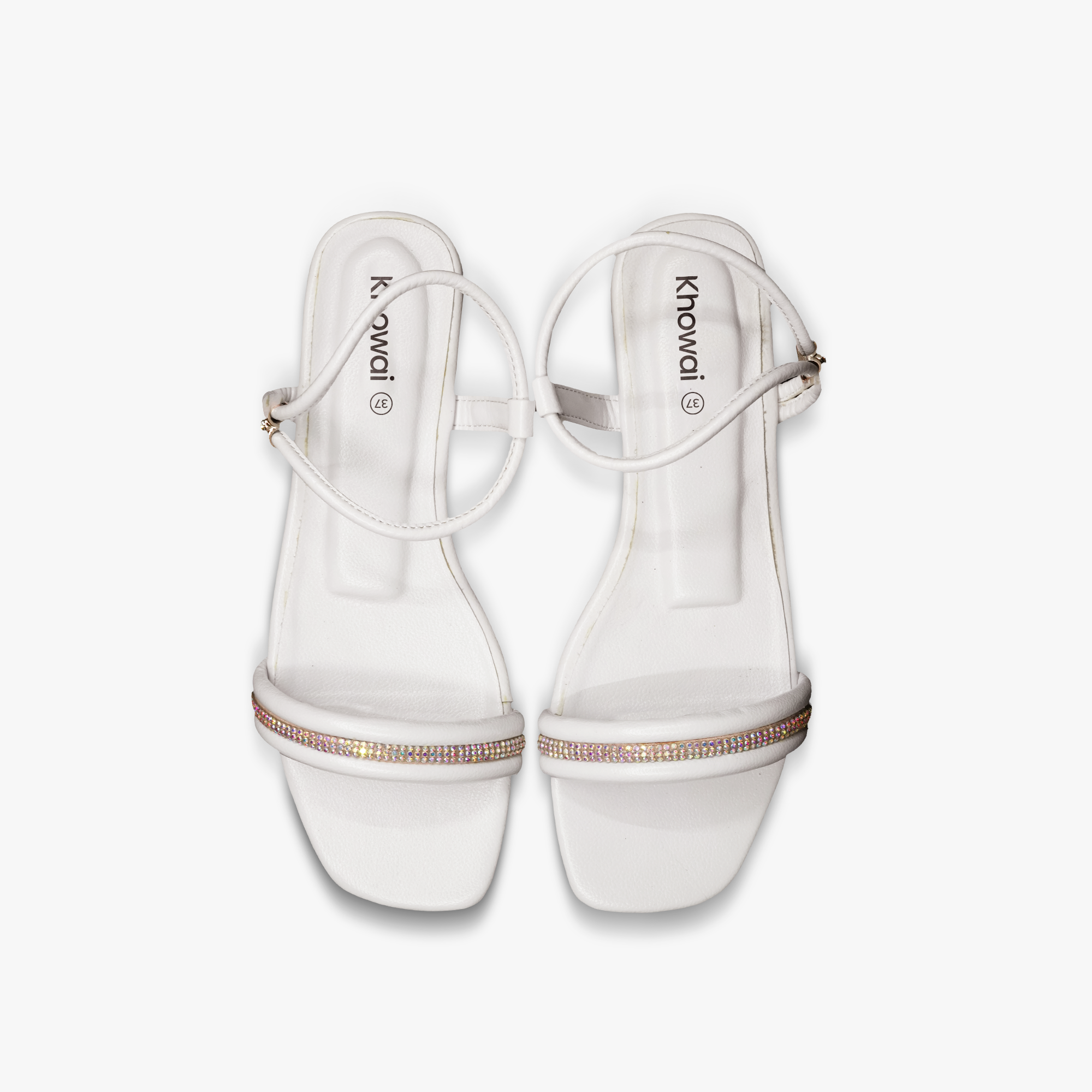 “Pair of Khowai white flat sandals with adjustable ankle strap and sparkly rhinestones”