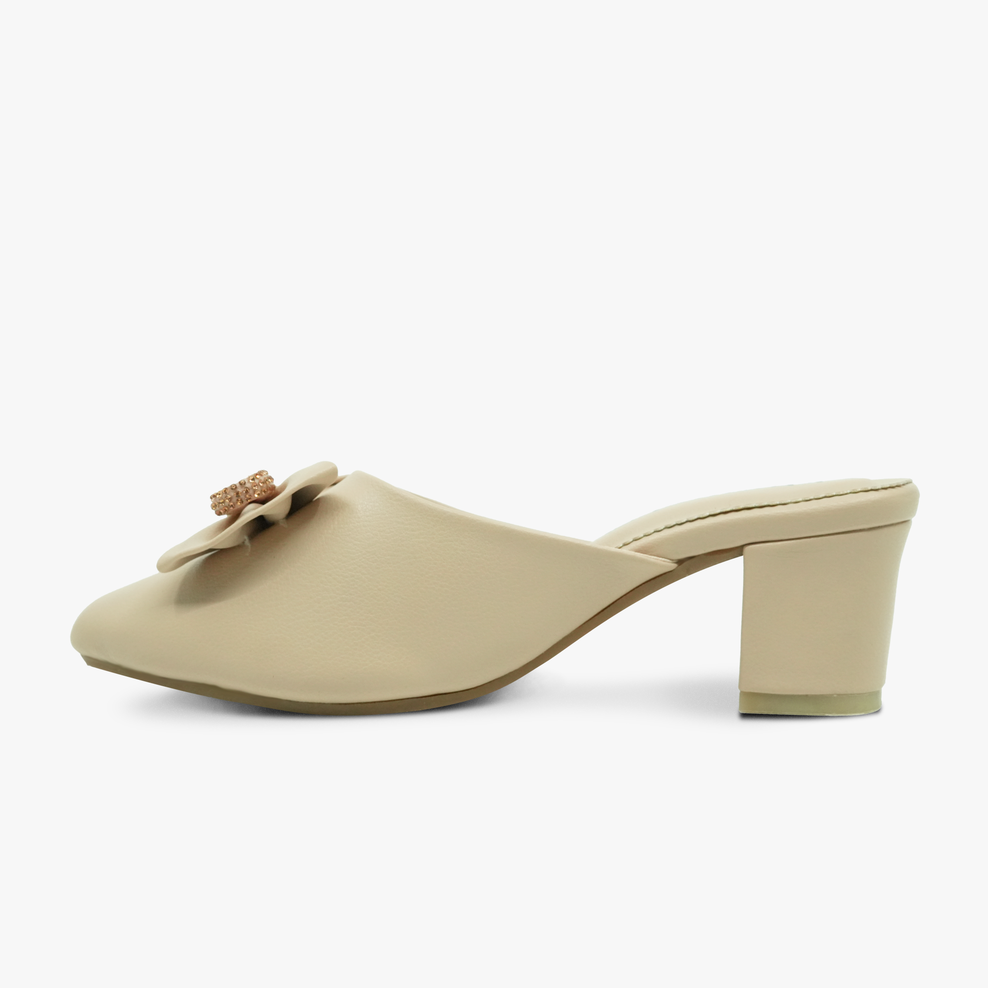 “Profile shot of closed-toe beige mule featuring a decorative bow accent”